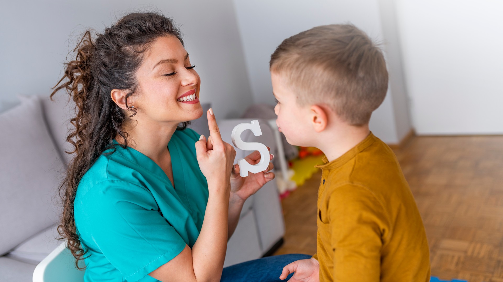 Speech therapist and little patient training articulation